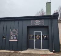 Außenbereich von Geschäftsräumen an der Košovská-Straße in Prievidza mit Informationstafeln.