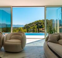 Wohnzimmer in der Villa mit Blick auf den Pool und die Natur.