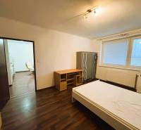 Schlafzimmer in einer 2-Zimmer-Wohnung mit Holzboden und einfachem Möbel.