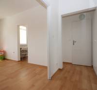 Innenraum einer Einzimmerwohnung, weiße Wände, Boden mit Holzdekor, Einbauschrank.