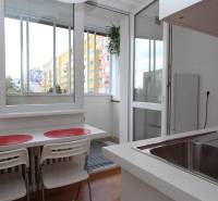 Küche in einer Einzimmerwohnung mit Aussicht und Balkon, Boden mit Holzdekor.