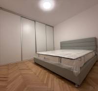Schlafzimmer in einer 2-Zimmer-Wohnung mit Holzboden und einem großen Einbauschrank.