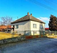 Ein Einfamilienhaus in der Sadova-Straße in Borský Mikuláš mit einem eingezäunten Garten und blauem Himmel.