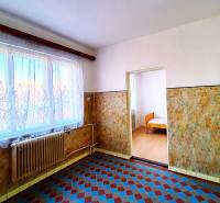 Innenraum eines Einfamilienhauses mit Fliesen, Heizkörper und Fenster mit Gardine.