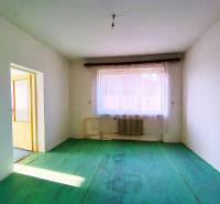 Ein Zimmer in einem Einfamilienhaus mit Heizkörper, grünem Boden, Blick auf die Dächer.