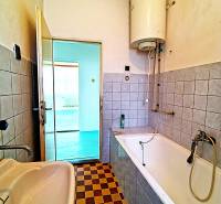 Ein Badezimmer in einem Einfamilienhaus mit einer Badewanne, einem Waschbecken und einem Schachbrettmuster-Fliesenboden.