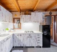 Eine Küche in einer Hütte mit einer Holzdecke und Vintage-Schränken, gemütliche Ausstattung.