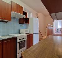 Küche in einem Einfamilienhaus mit Holzdekor, blauen Fliesen und Küchenzeile.