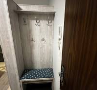 Eingangsflur mit Kleiderhaken und Bank in einer 2-Zimmer-Wohnung.