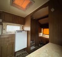 Innenraum mit Holzboden, Küchenzeile und Bett in einem Grundstück - Wohnen.