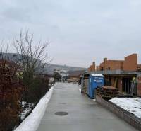 Bau eines Einfamilienhauses in einer verschneiten Straße in Višňové im Rohbauzustand.