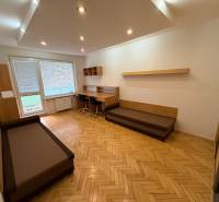 Wohnzimmer in einer 3-Zimmer-Wohnung mit Holzboden und Schreibtisch.