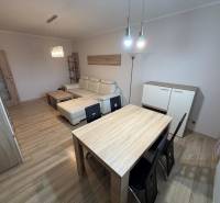 Wohnzimmer mit Holzboden, Sofa und Tisch in einer 3-Zimmer-Wohnung.