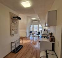 Innenraum eines Einfamilienhauses mit Küche und Essbereich, Boden mit Holzdekor.