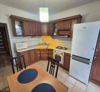 Küche mit dunklem Holzdekor, Herd und Kühlschrank in einer 3-Zimmer-Wohnung.