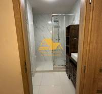 Badezimmer mit Dusche und Waschbecken in einer 2-Zimmer-Wohnung, mit Fliesen in hellen Tönen.