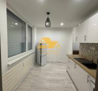 Küche in einer Einzimmerwohnung mit Holzboden und moderner Beleuchtung.