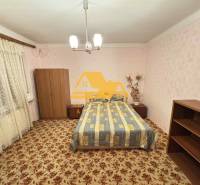 Schlafzimmer im Einfamilienhaus mit Teppichboden und Möbeln, zarte rosa Tapeten.