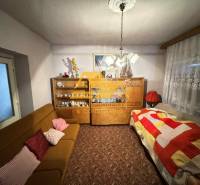 Wohnzimmer in einem Einfamilienhaus mit Teppich, Sofa und Schrank mit Porzellan.