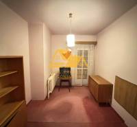 Ein Raum in einem Einfamilienhaus mit Möbeln und Vorhängen, ohne Bodenbelag mit Holzdekor.