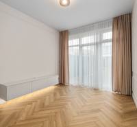 Wohnzimmer in einer 2-Zimmer-Wohnung mit Holzboden und weißen Möbeln.