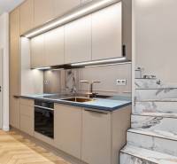 Küche in einer 2-Zimmer-Wohnung mit Marmortreppe und Boden in Holzoptik.