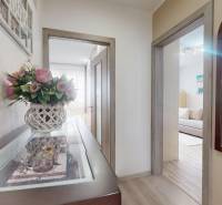 Flur in einer 3-Zimmer-Wohnung mit Blumendekoration und Holzboden.