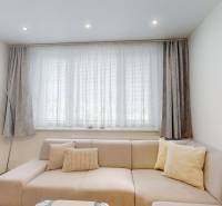 Wohnzimmer mit Sofa und Vorhängen in einer 3-Zimmer-Wohnung.