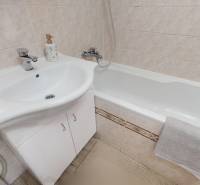 Badezimmer in einer 3-Zimmer-Wohnung mit Badewanne, Waschbecken und Fliesen.