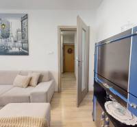 Wohnzimmer in einer 3-Zimmer-Wohnung mit einer Eckcouch und einem Boden in Holzoptik.