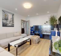 Wohnzimmer in einer 3-Zimmer-Wohnung mit dekorativem Bild und Boden in Holzoptik.