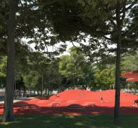 Ein Park mit einem roten Spielplatz in der Golianova-Straße in Trnava, umgeben von Bäumen und Bänken.