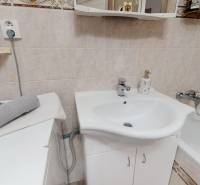 Badezimmer in einer 3-Zimmer-Wohnung mit Waschbecken, Badewanne und Fliesen in neutralen Tönen.