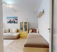 Wohnzimmer in einer 3-Zimmer-Wohnung mit Sofas, Kommode und Boden mit Holzdekor.
