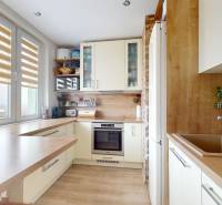 Küche mit Holzboden, hellen Schränken und Aussicht in einer 3-Zimmer-Wohnung.