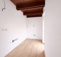 Innenraum eines Einfamilienhauses mit Holzboden und einer Decke mit Holzbalken.