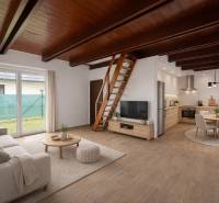 Wohnzimmer mit Küche in einem Einfamilienhaus, Treppen, Sofa, Fernseher, Esstisch, Boden mit Holzdekor.