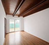 Ein Zimmer in einem Einfamilienhaus mit einem Boden in Holzoptik und einem großen Fenster.