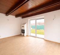 Innenraum eines Einfamilienhauses mit Holzboden und großen Fenstern zum Garten.