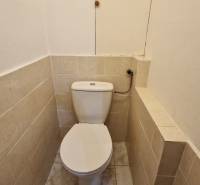 Toilette mit Fliesen in einer 2-Zimmer-Wohnung mit einfacher Ausstattung.