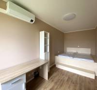 Schlafzimmer in einer 3-Zimmer-Wohnung mit Holzboden, Bett und Schreibtisch.