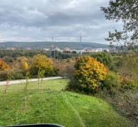 Herbstlandschaft in Bratislava - Dúbravka auf der Nejedlého, mit bunten Bäumen und einem Himmel voller Wolken.