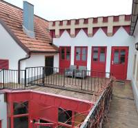 Hof mit Terrasse und roten Türen, umgeben von Architektur in den Büros an der Hauptstraße in Eisenstadt.