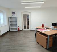 Büros mit Holzboden, Tisch und leerem Regal.