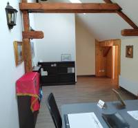 Büros mit Balken und Holzboden, Regale mit Decke, Tisch mit Dokumenten.