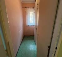 Ein schmaler Raum mit einem Einbauschrank und einem Vorhang in einer 3-Zimmer-Wohnung.