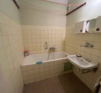 Badezimmer in einer 3-Zimmer-Wohnung mit Badewanne, Waschbecken und Fliesen an den Wänden.