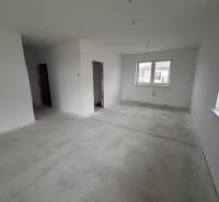 Innenraum eines Einfamilienhauses mit weißen Wänden und Betonboden.