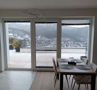 Essbereich in einer 2-Zimmer-Wohnung mit Blick auf schneebedeckte Hügel und Terrasse.