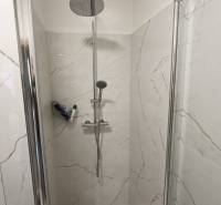 Duschkabine mit Marmorverkleidung in einer 2-Zimmer-Wohnung.